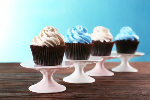 Cupcakes de chocolate sobre mesa de madera delante de fondo azul — Foto de Stock