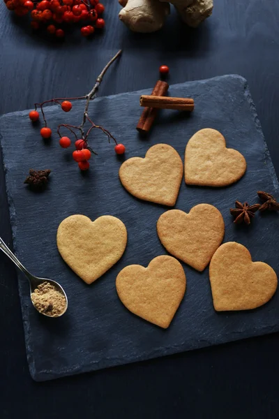 Galletas en forma de corazón con fresas en una esterilla —  Fotos de Stock