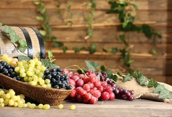 Grapes in bowl and barrel on wooden table — Stock Photo, Image