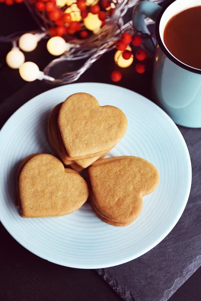Biscotti a forma di cuore su piatto e tazza su un tavolo, vista dall'alto — Foto Stock