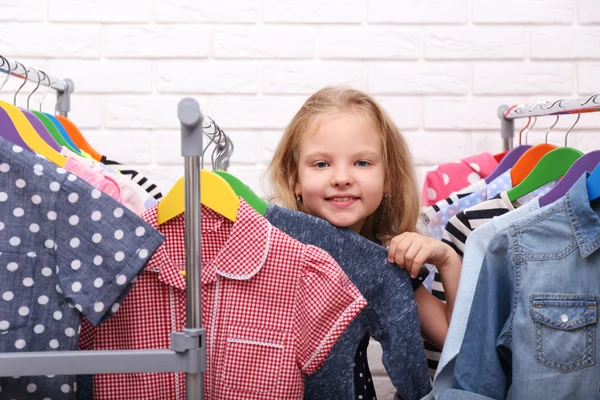 Liten flicka försöker på kläder — Stockfoto