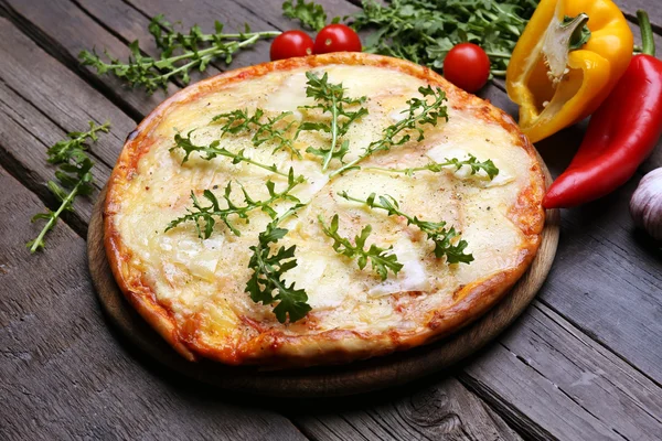 Ízletes pizza díszített fűszernövények és zöldségek fából készült háttér, közelről — Stock Fotó