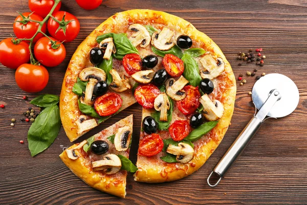 Pizza saborosa fatiada deliciosa com legumes na mesa de madeira — Fotografia de Stock