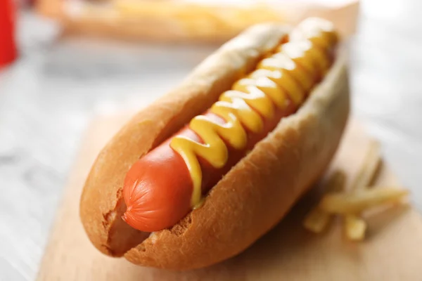 Hot dog with fried potatoes on craft paper — Stock Photo, Image