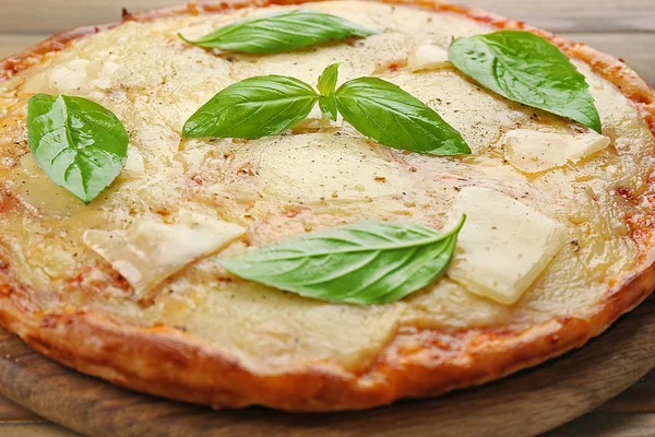 Tasty pizza decorated with basil  on wooden background, close up — Stock Photo, Image