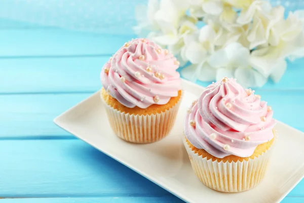 Rózsaszín cupcakes a fából készült háttér — Stock Fotó
