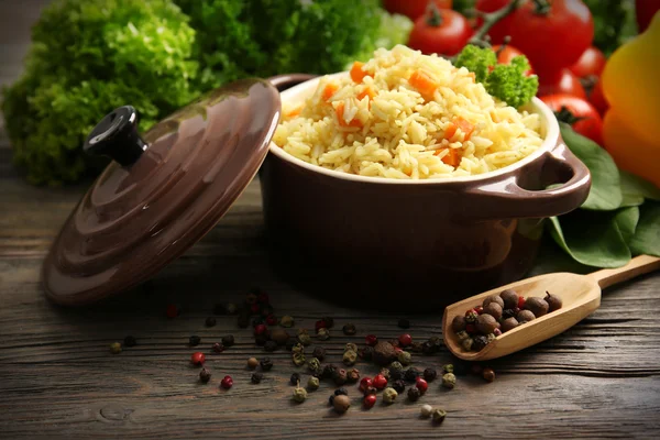 Pan av vegetariska ris med grönsaker och kryddpeppar på träbord närbild — Stockfoto