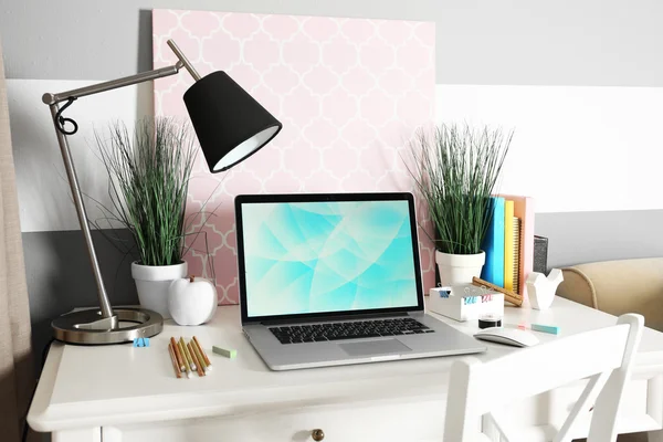 Posto di lavoro con tavolo, lampada e laptop in salotto — Foto Stock