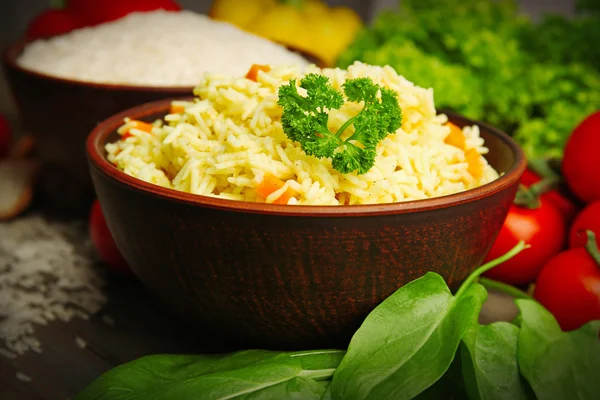 Skålar av ris och grönsaker på träbord närbild — Stockfoto