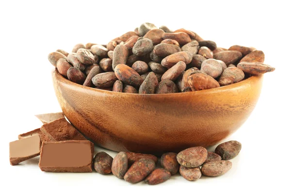 Cuenco con granos de cacao aromáticos y chocolate aislado sobre fondo blanco, de cerca — Foto de Stock