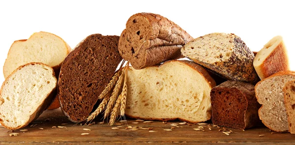 Couper le pain frais cuit et les épis de blé, isolés sur du blanc — Photo