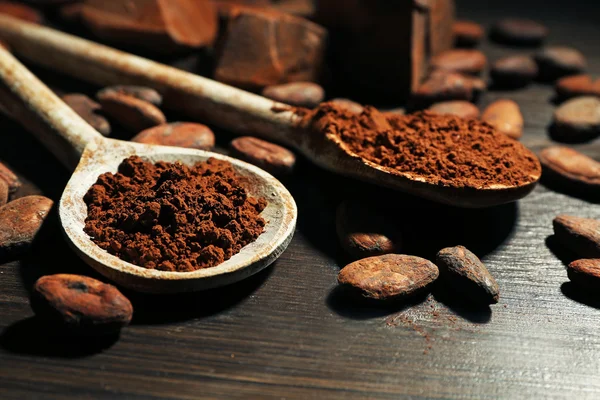 Spoon with aromatic cocoa and chocolate on wooden background, close up — Stock Photo, Image