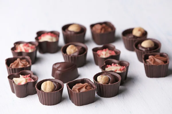 Set di caramelle al cioccolato su uno sfondo di legno chiaro, primo piano — Foto Stock