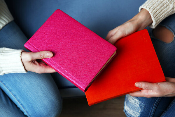Woman giving book to woman