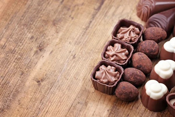 Köstliche Schokoladenbonbons auf hölzernem Hintergrund — Stockfoto