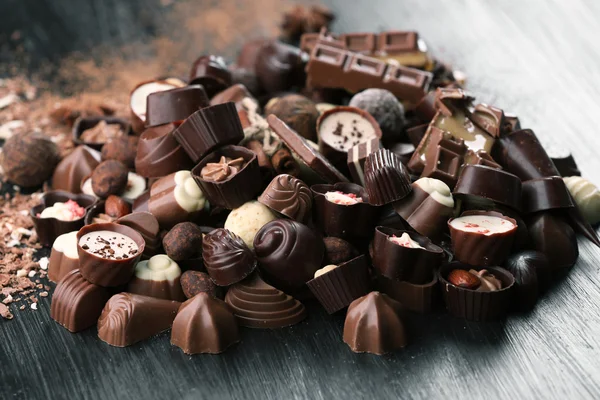 Auswahl an leckeren Schokoladenbonbons auf Holztischhintergrund — Stockfoto