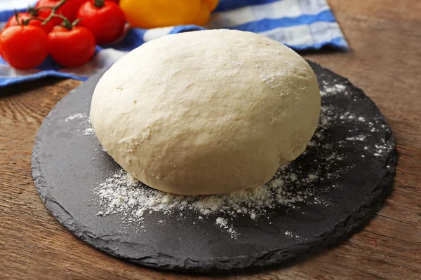 Fresh prepared dough on a black wooden board, close up — ストック写真