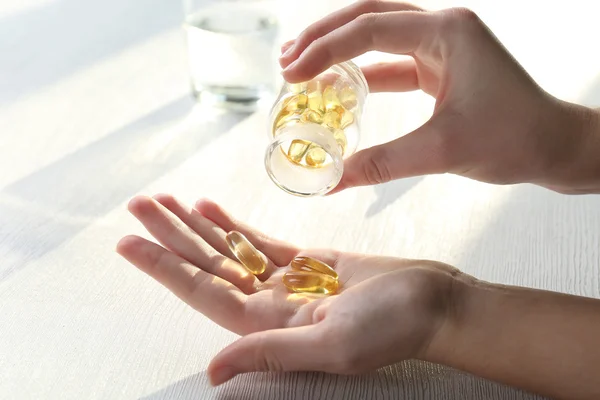 Pílulas em mãos femininas — Fotografia de Stock