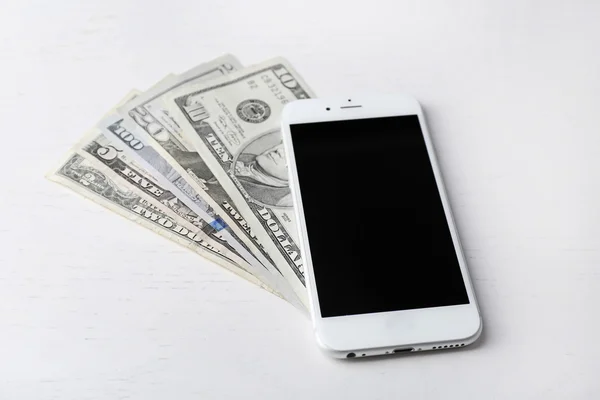 Smart phone on dollar banknotes over light table. Internet earning concept — Stock Photo, Image