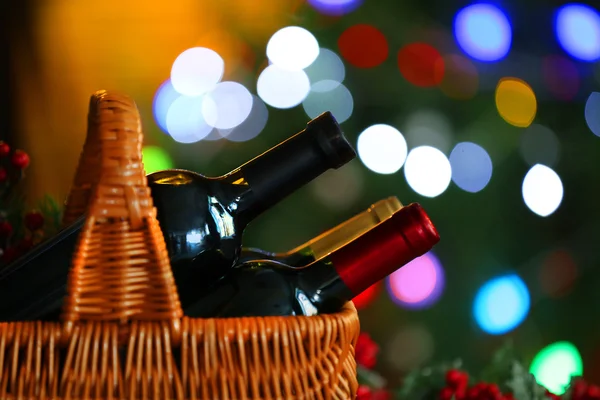 Víno v koši na pozadí vánoční stromeček — Stock fotografie
