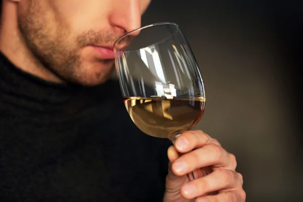 Человек нюхает белое вино — стоковое фото