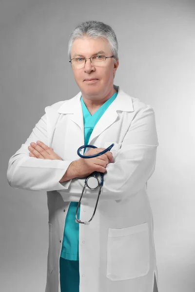 Handsome doctor on grey — Stock Photo, Image