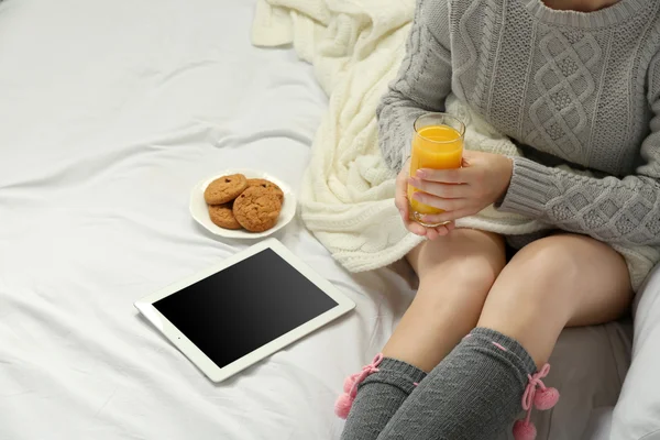 Жінка з таблетками п'є апельсиновий сік на її ліжку — стокове фото
