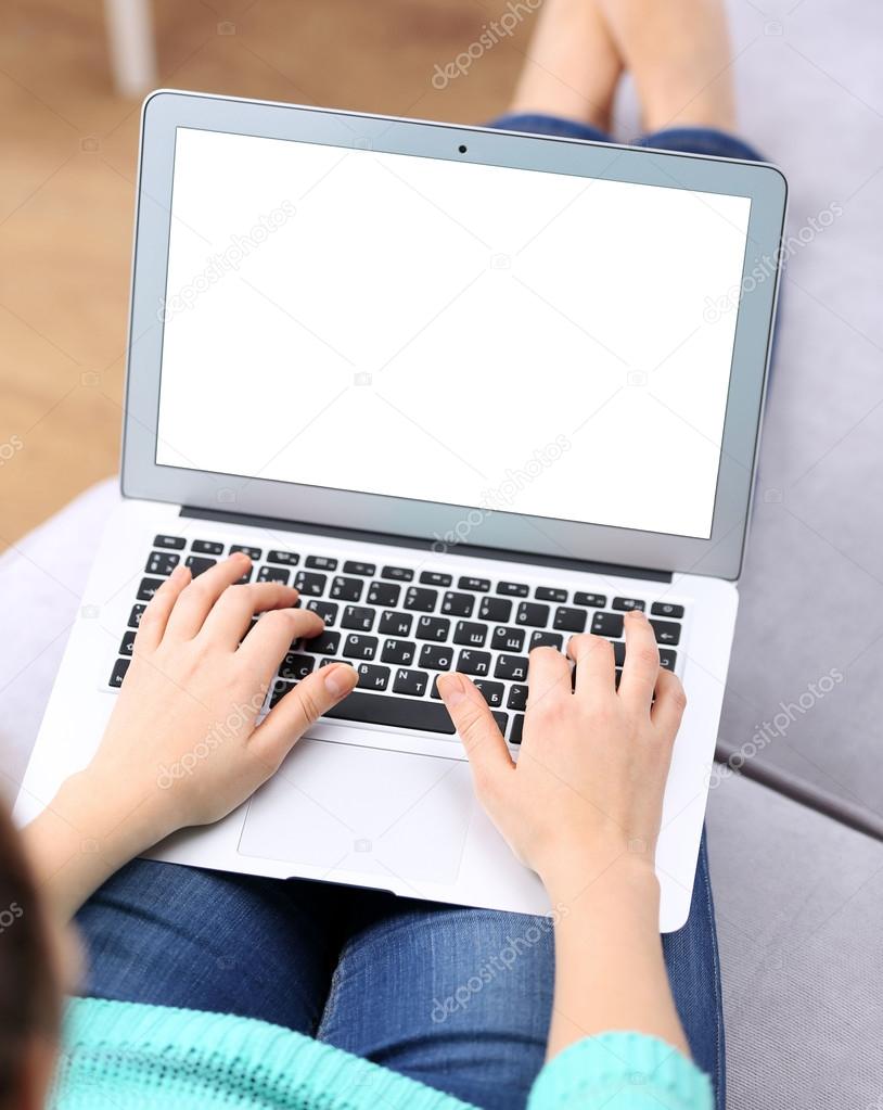 Woman sitting on sofa with laptop 