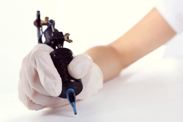 Hand in de handschoen met tattoo machine — Stockfoto