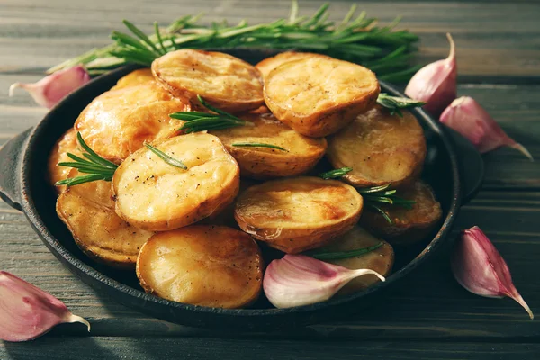 Läckra bakad potatis med rosmarin i stekpanna på bordet på nära håll — Stockfoto