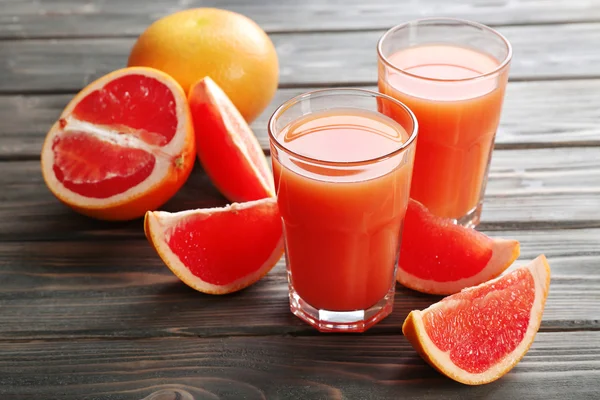 Glass of grapefruit juice and fresh fruits on wooden background — Stock Photo, Image