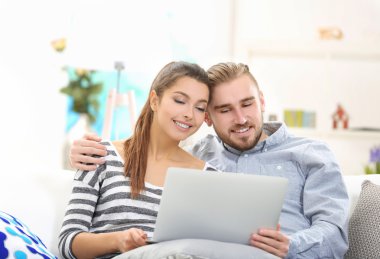 Mutlu bir çift ve bir dizüstü bilgisayar üzerinde çalışan