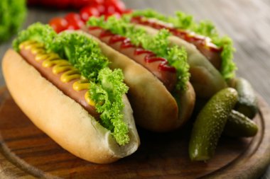 Ahşap masa üzerinde sebze ile lezzetli hot-dogs, yakın çekim