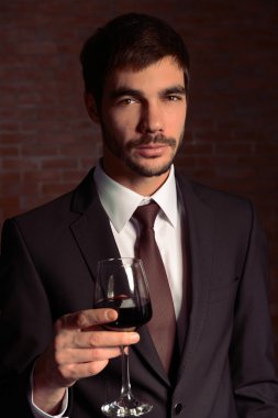 Kırmızı şarap ile takım elbiseli adam