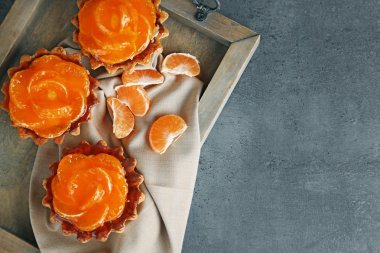 Tatlı kek üzerinde karanlık metal masa, mandalina ile yakın çekim