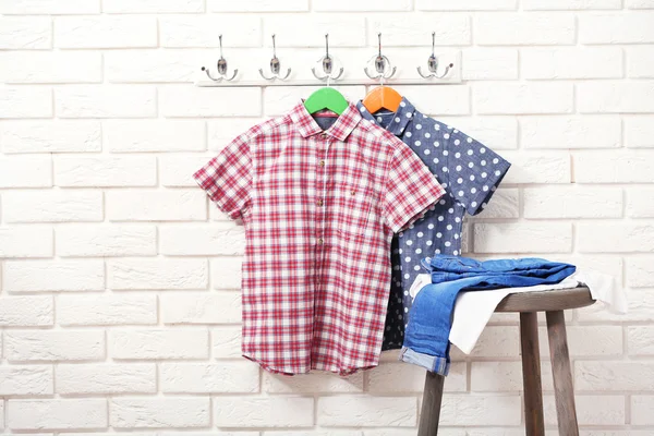 Kleding op kleerhangers in een kamer — Stockfoto