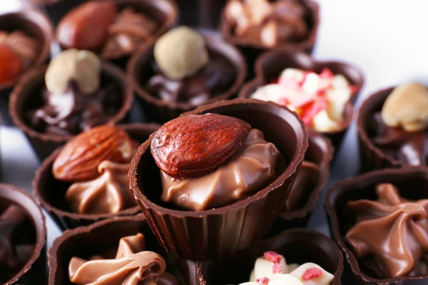 Deliciosos caramelos de chocolate sobre fondo blanco, de cerca —  Fotos de Stock
