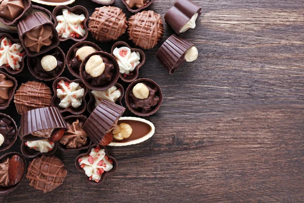 Deliciosos caramelos de chocolate sobre fondo de madera, de cerca — Foto de Stock