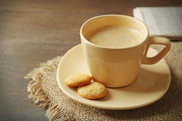 Tasse Kaffee, Kekse und Zeitung auf Holztischhintergrund — Stockfoto