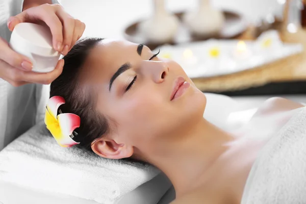 Massaggiatore mettendo crema sul viso della donna — Foto Stock