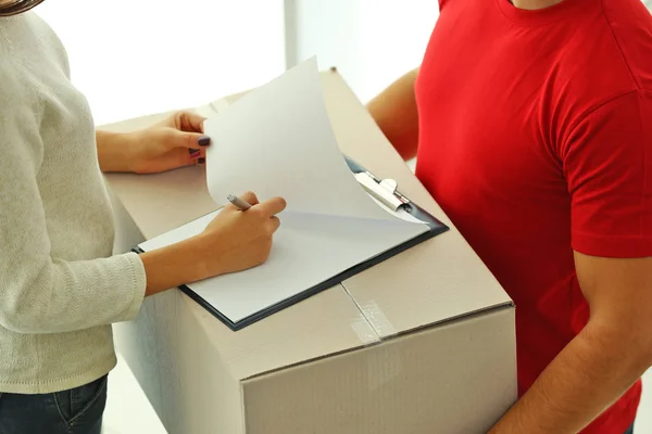 Woman signing delivery receipt — Stock Photo, Image