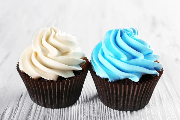 Fresh delicious cupcakes in a row on white wooden  background — Stock Photo, Image