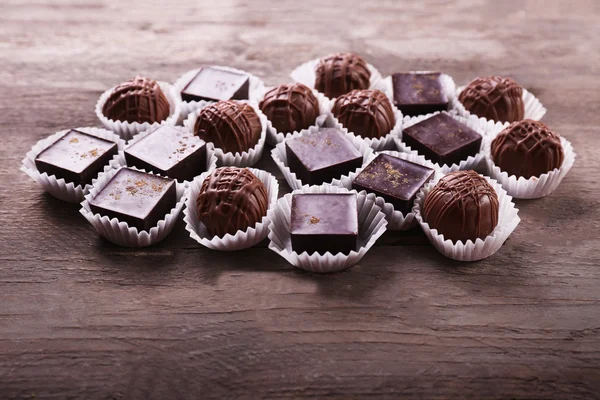 Verschiedene Schokoladenbonbons auf Holzgrund — Stockfoto