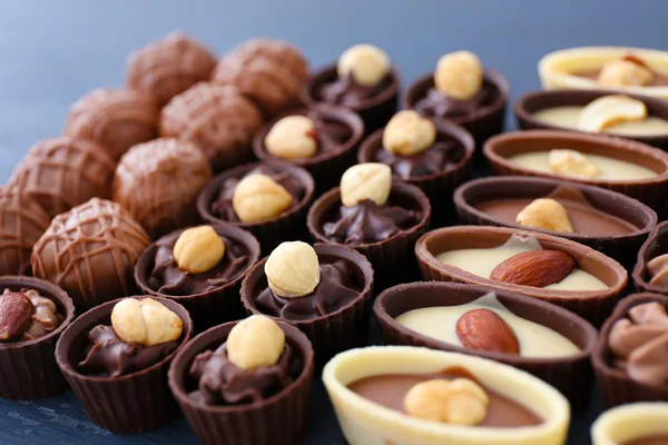 Heerlijke chocolade snoepjes op blauwe houten achtergrond, close-up — Stockfoto