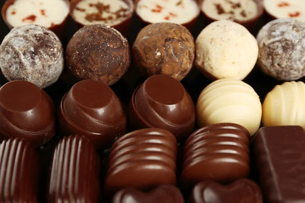 Assorted chocolate candies on black background, close up — Stock Photo, Image