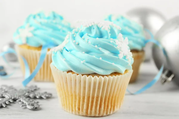Wenige leckere blaue Cupcakes mit Dekorationen auf hellem Hintergrund — Stockfoto