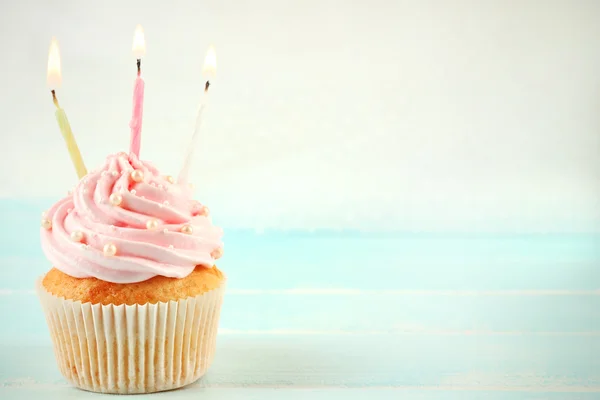 Tasty pink cupcakes decorated with candles on light background — Stock Photo, Image