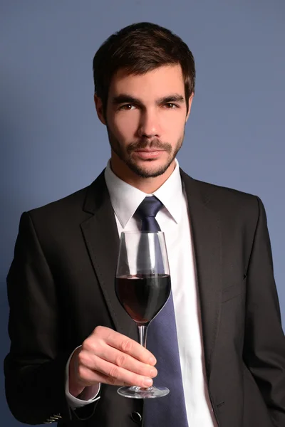 Человек в костюме с красным вином — стоковое фото
