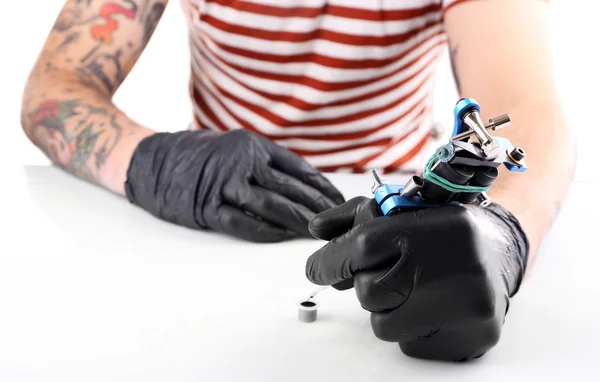 Mãos de tatuador em luvas com máquina de tatuagem — Fotografia de Stock