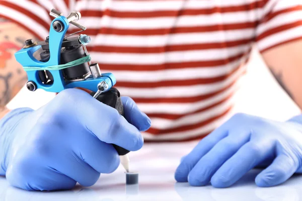 Tattooist hands in gloves with tattoo machine — Stock Photo, Image